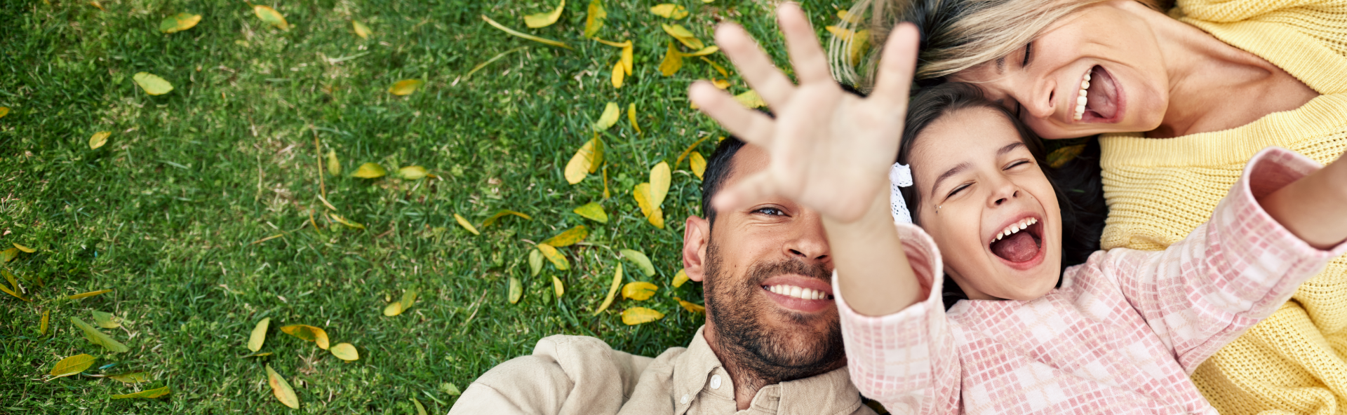 Smiling family lying in the grass